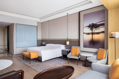 上海上海宝华喜来登酒店的酒店客房,配有床和桌椅