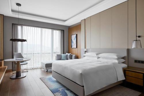 温州温州空港万豪酒店的卧室配有一张白色的大床和一张沙发。