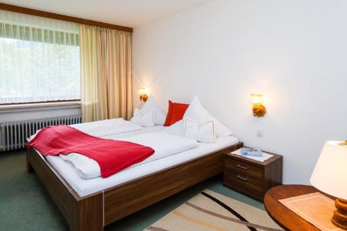 鲁波尔丁Gästehaus beim Schneidersepp的一间卧室配有一张床铺,床上铺有红色毯子