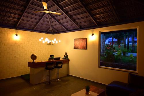 奇克马格尔Shree Kalya Resort- Chikmagalur的客房配有书桌和吊扇。