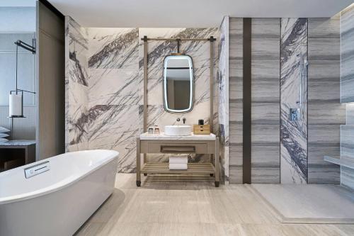 无锡无锡鲁能万豪酒店的带浴缸、水槽和镜子的浴室
