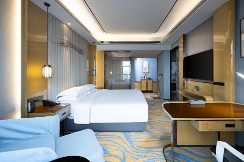 南昌南昌万怡酒店的配有一张床和一张书桌的酒店客房