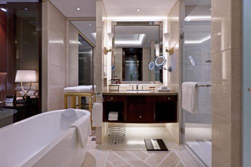 常州Sheraton Changzhou Wujin Hotel的带浴缸、水槽和镜子的浴室