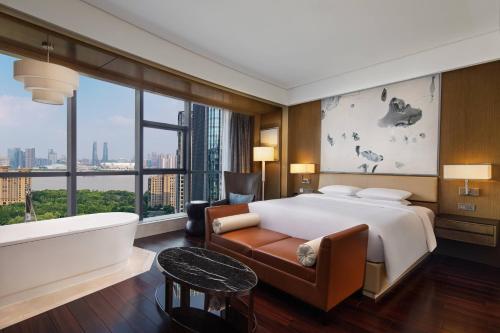 杭州杭州钱江新城万怡酒店的一间卧室设有一张大床、一个浴缸和一个浴缸。