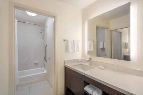 印第安纳波利斯印第安纳波利斯机场住宅酒店的一间带水槽、淋浴和镜子的浴室