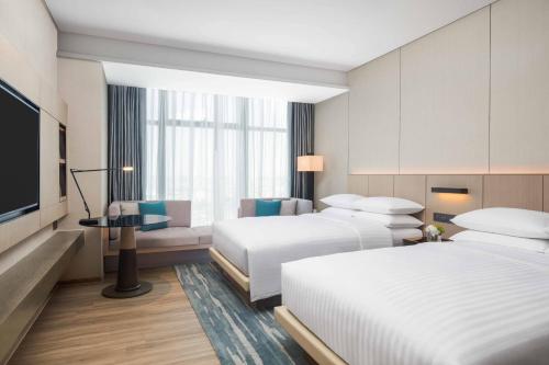 宝安深圳联投东方万怡酒店的酒店客房设有两张床和一台平面电视。