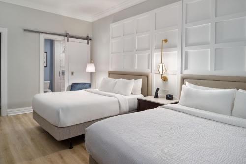 新奥尔良新奥尔良法国区/伊贝维尔万怡酒店的酒店客房,配有两张床和椅子