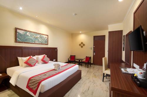 库塔伊斯坦纳拉玛大酒店的一间卧室配有一张床、一张书桌和一台电视