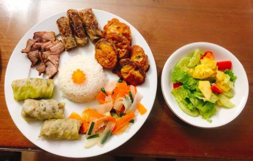 高平Gia Bảo Homestay - Cao Bằng的盘子上放着肉饭和蔬菜