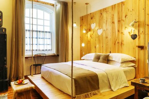里斯本262精品酒店的一间卧室设有秋千床和窗户。