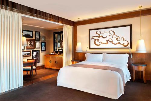拉萨拉萨瑞吉度假酒店的卧室配有一张白色大床和一张书桌