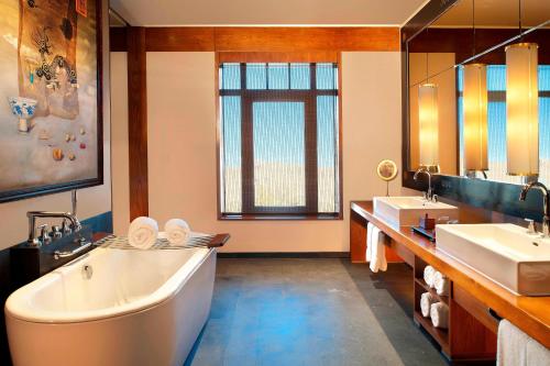 拉萨拉萨瑞吉度假酒店的大型浴室设有两个盥洗盆和浴缸。