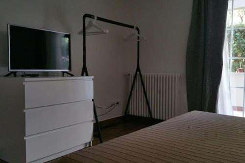 里乔内Cristina’s flat Riccione的一间卧室配有梳妆台,上面配有电视
