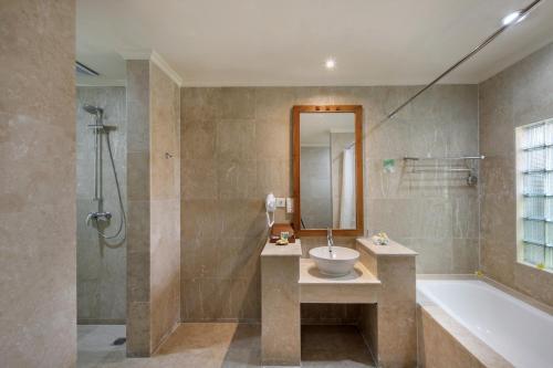 库塔伊斯坦纳拉玛大酒店的浴室配有水槽、淋浴和浴缸。
