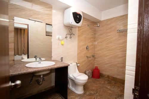 甘托克Tiara Regency Gangtok的浴室配有卫生间、盥洗盆和淋浴。