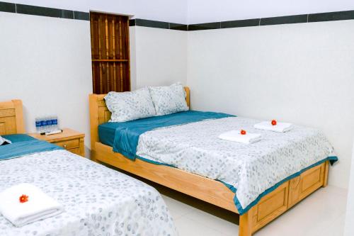 罗夷Đại Dương La Gi Homestay & Coffee的一间卧室配有两张床,并备有托盘。