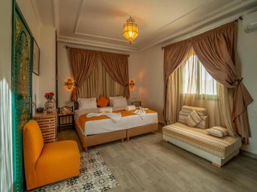 马拉喀什Riad Dar Sido的一间卧室配有两张床和椅子