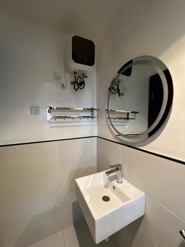 拉各斯COC00N by IVY的白色的浴室设有水槽和镜子