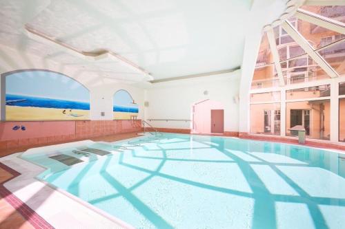 奥斯特西巴德钦诺维茨海滩珍珠酒店的一座大型游泳池,位于一座带大窗户的建筑内