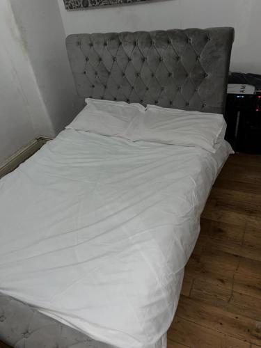 伦敦Come stay x的白色的床,配有灰色床头板和白色床单