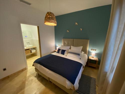 圣雷米普罗旺斯Les Logis de Cocagne的一间卧室设有一张大床和蓝色的墙壁