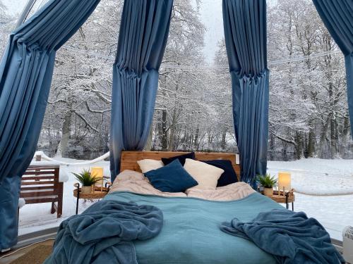 布罗斯Borås Camping & Vandrahem的一间卧室配有蓝色窗帘和雪床