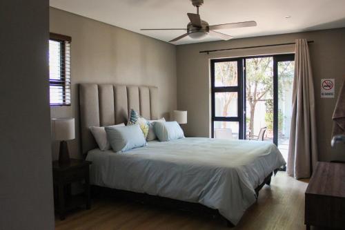 比勒陀利亚Annexure A - Lovely brand new 2 bedroom flat in Groenkloof的一间卧室配有一张大床和吊扇