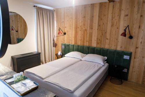 思贝儿The River Chalet的卧室配有一张床铺,位于带木墙的房间内