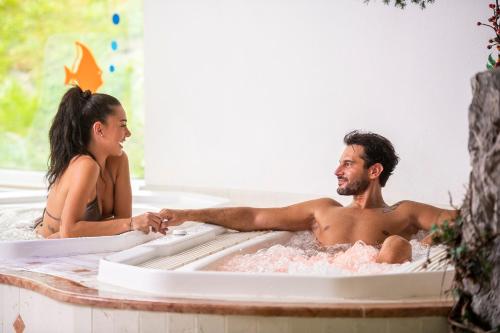 佩伊奥Alpino Charme Apartments的坐在浴缸里的男人和女人