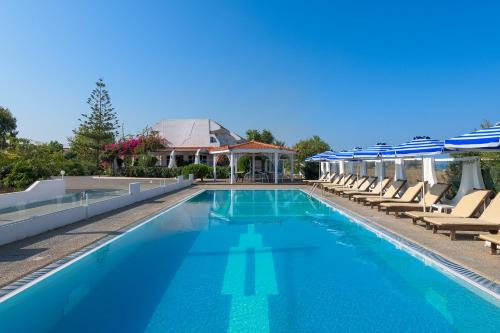 塞奥洛戈斯尼瓦纳海滩酒店的一个带躺椅和遮阳伞的大型游泳池