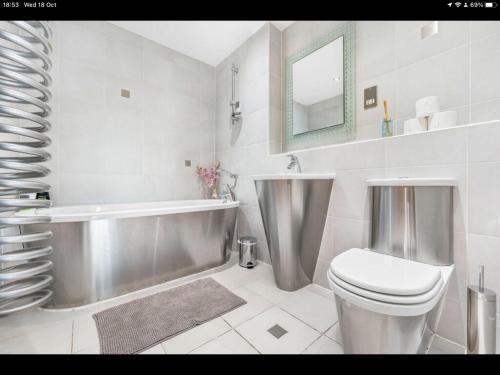 卡迪夫Stunning Spacious City Apartment with free parking的浴室配有卫生间、浴缸和水槽。