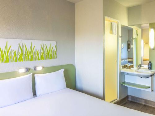 维勒纳夫多尔农南基波尔多宜必思快捷酒店的一间卧室配有一张床,浴室设有水槽