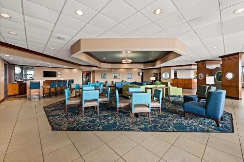 斩魔山海滨康福特茵酒店的酒店大堂设有等候区、桌子和椅子