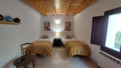 LiríCasa Castan的带窗户的客房内设有两张单人床。