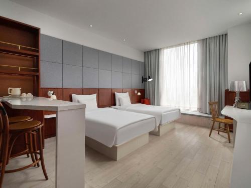 上海上海虹桥会展诺富特酒店的酒店客房配有两张床和一张书桌