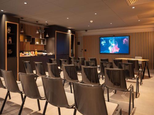 丰特奈苏布瓦Novotel Paris Val de Fontenay的一间会议室,配有椅子和平面电视