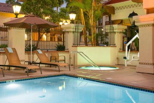 圣地亚哥圣地亚哥老城万怡酒店的一个带椅子和遮阳伞的游泳池