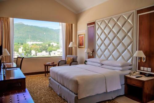 伊斯兰堡伊斯兰堡万豪酒店 的一间卧室设有一张大床和一个大窗户