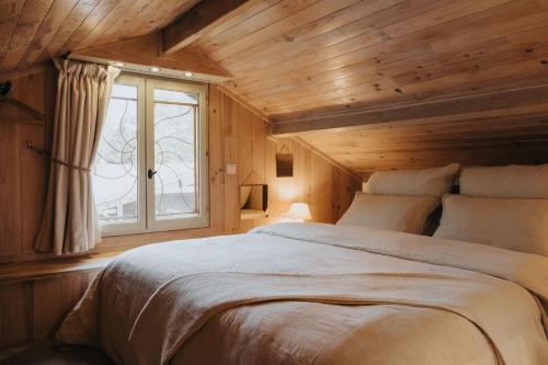 博兰refuges的一间卧室设有一张大床和一个窗户。