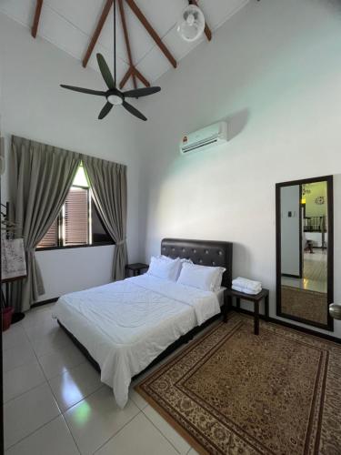 Kampong Bukit KatilTraditional Melaka Homestay with Private Pool的一间卧室配有一张床和吊扇