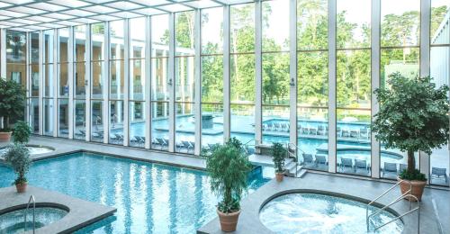 巴特萨罗皮斯库夫Victoria Suites的一座室内游泳池,位于一座带窗户的建筑中