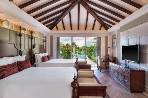 三亚三亚海棠湾JW万豪度假酒店(西班牙风情+迷你吧）的一间带大床和电视的卧室