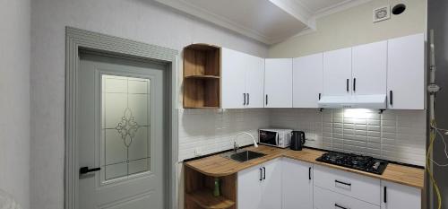 奥什Квартира со всеми удобствами的厨房配有白色橱柜和白色门