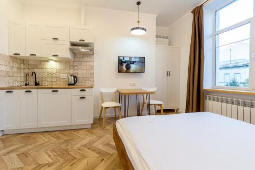 基辅Idea Design Apart-Hotel Chykalenka的一间卧室配有一张床,厨房配有桌子