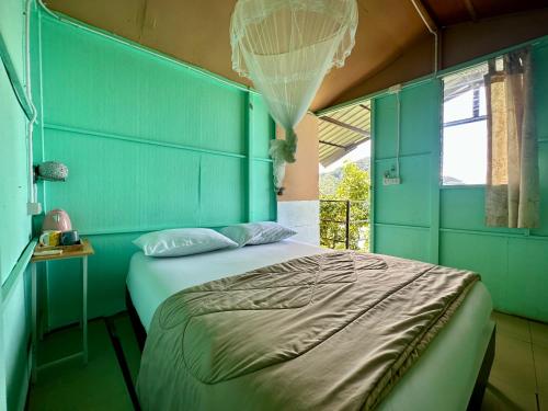 皮皮岛Phi Phi Seaside Bungalow的一间卧室配有一张蓝色墙壁的床