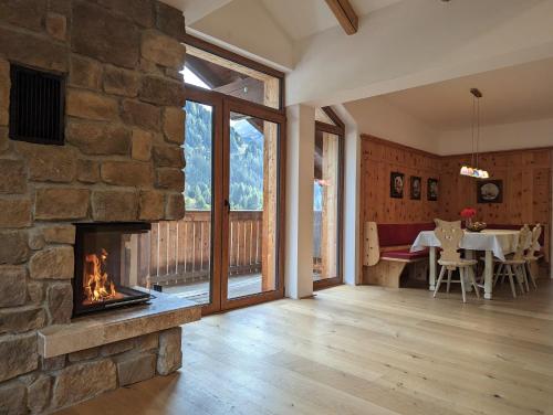 圣安东阿尔贝格ARLhome Lodge - Zuhause am Arlberg的一间带石头壁炉的客厅和一间带桌子的用餐室
