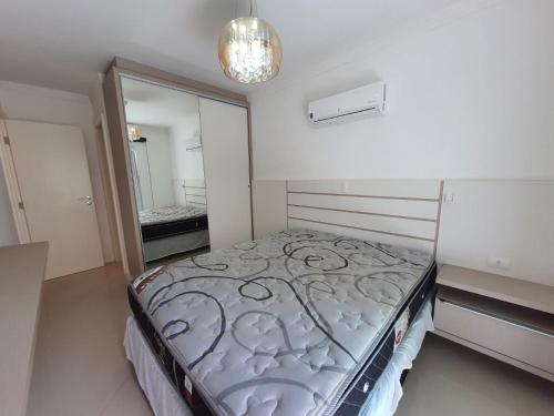 邦巴斯Apartamento a 60m da praia de Bombas的一间卧室配有一张床和镜子