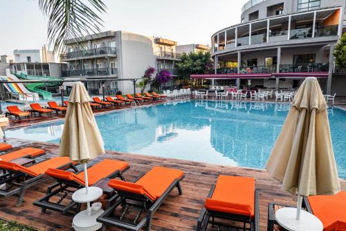 居姆贝特博德鲁姆海滨度假酒店的一座带椅子和遮阳伞的游泳池