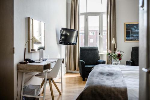 皮特奥皮特奥城市酒店的酒店客房配有一张床、一张书桌和一台电视。