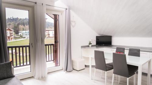安达洛Appartamento Stella的一间带桌椅的白色用餐室和一个阳台